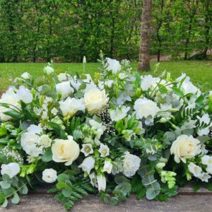 White funeral flowers double-ended coffin spray with roses and seasonal blooms