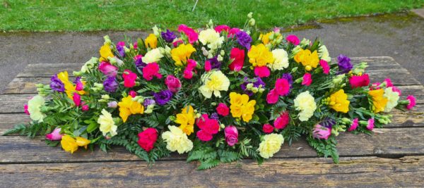 vibrant coffin spray-funeral flowers-colourful-bright flower spray-double ended casket spray-funeral flowers-florist-torbay